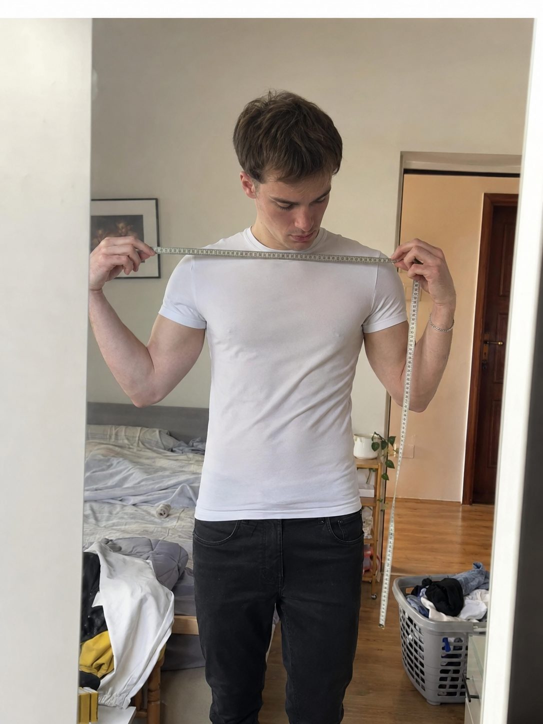Measuring a shoulder seam with a tape measure on a slim-fit shirt