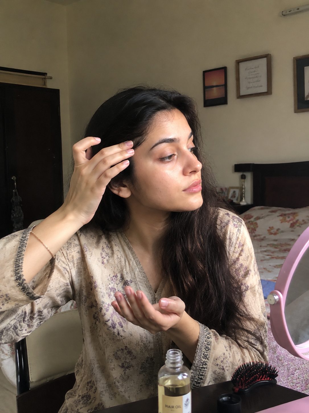 Applying a small drop of oil along the hairline before wrapping a hijab