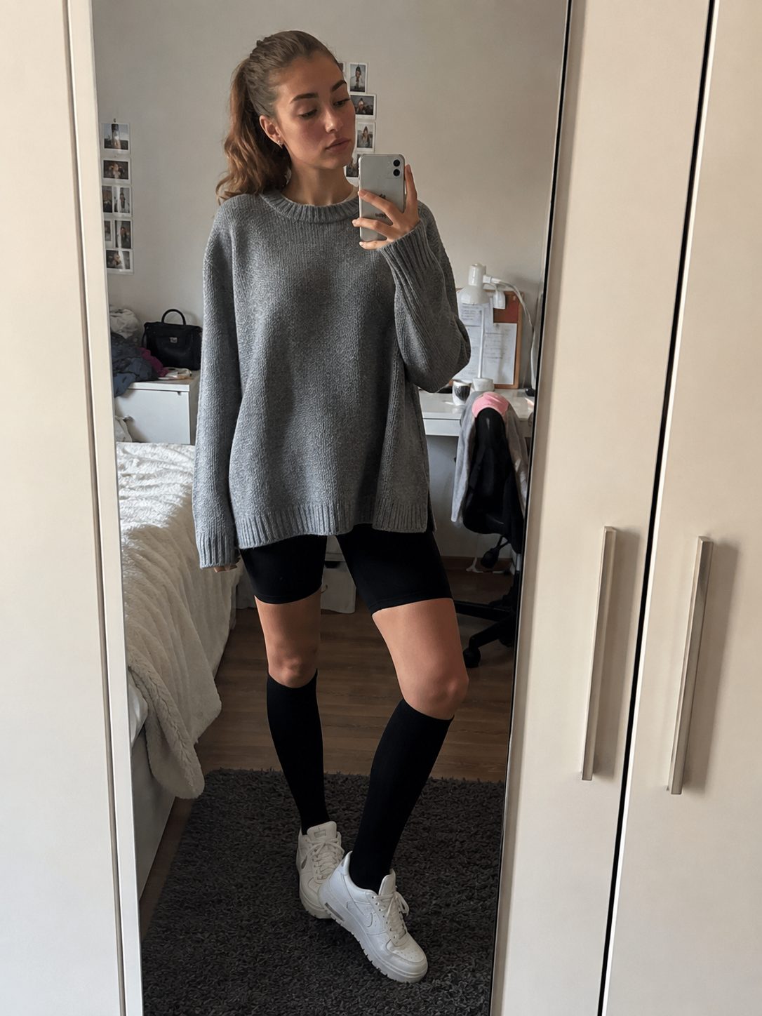White lace dress styled with all-black knee-high socks, shoes, and bag for date night