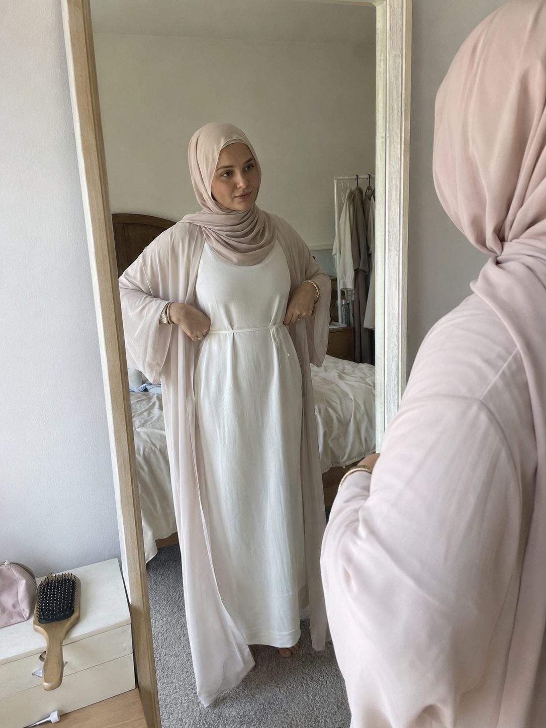 Layering a white slip dress underneath a sheer light-colored abaya